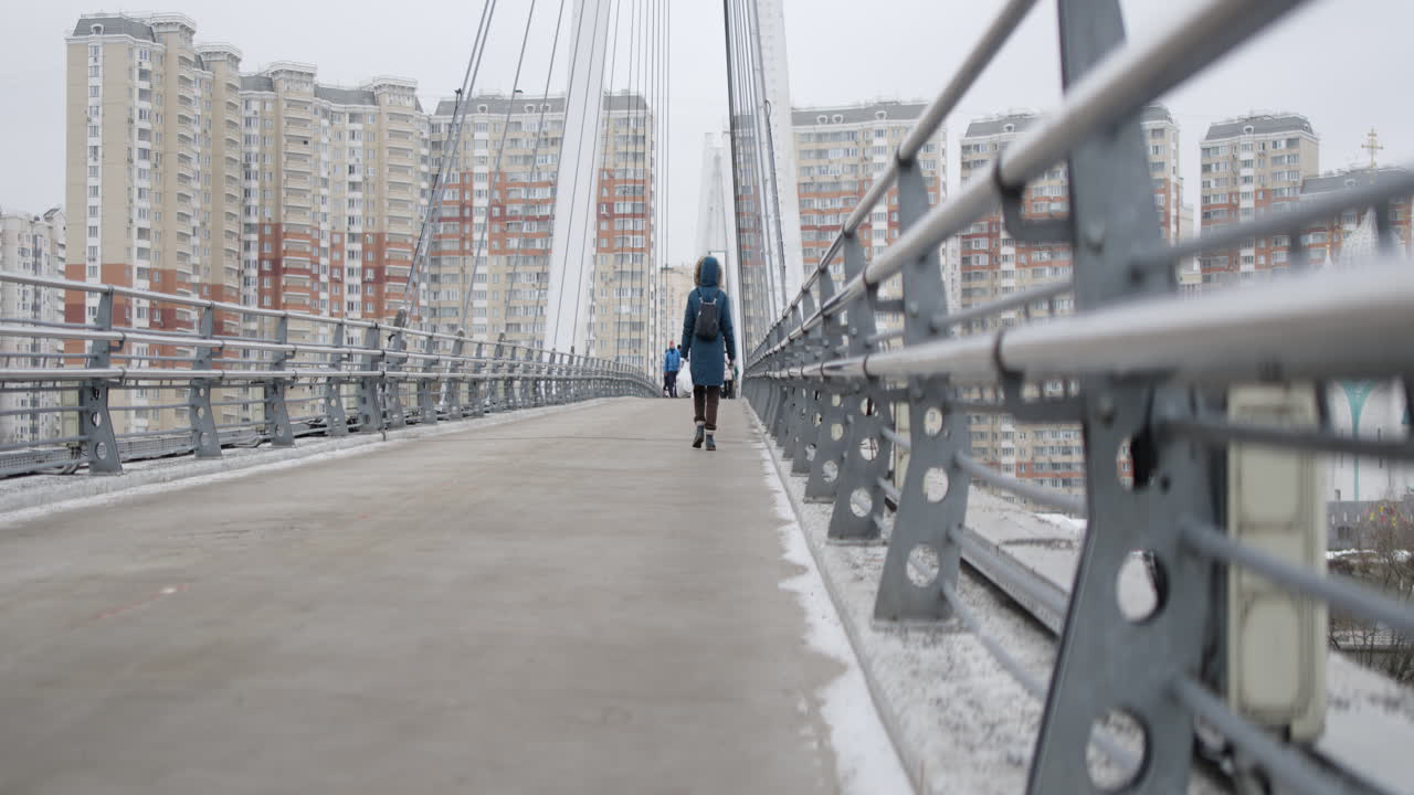 Person Walking on a Bridge in a City on a Cold Winter Day