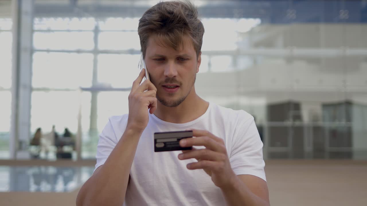 hombre sonriente dictando el número de la tarjeta al interlocutor a través del teléfono.