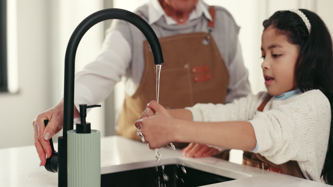 Child and Grandmother Washing Hands in Kitchen