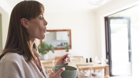 Middle-aged-Caucasian-woman-enjoys-a-healthy-meal-at-home,-with-copy-space