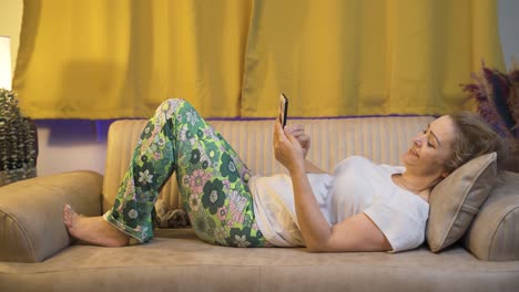 mujer enviando mensajes de texto por teléfono en la cama.