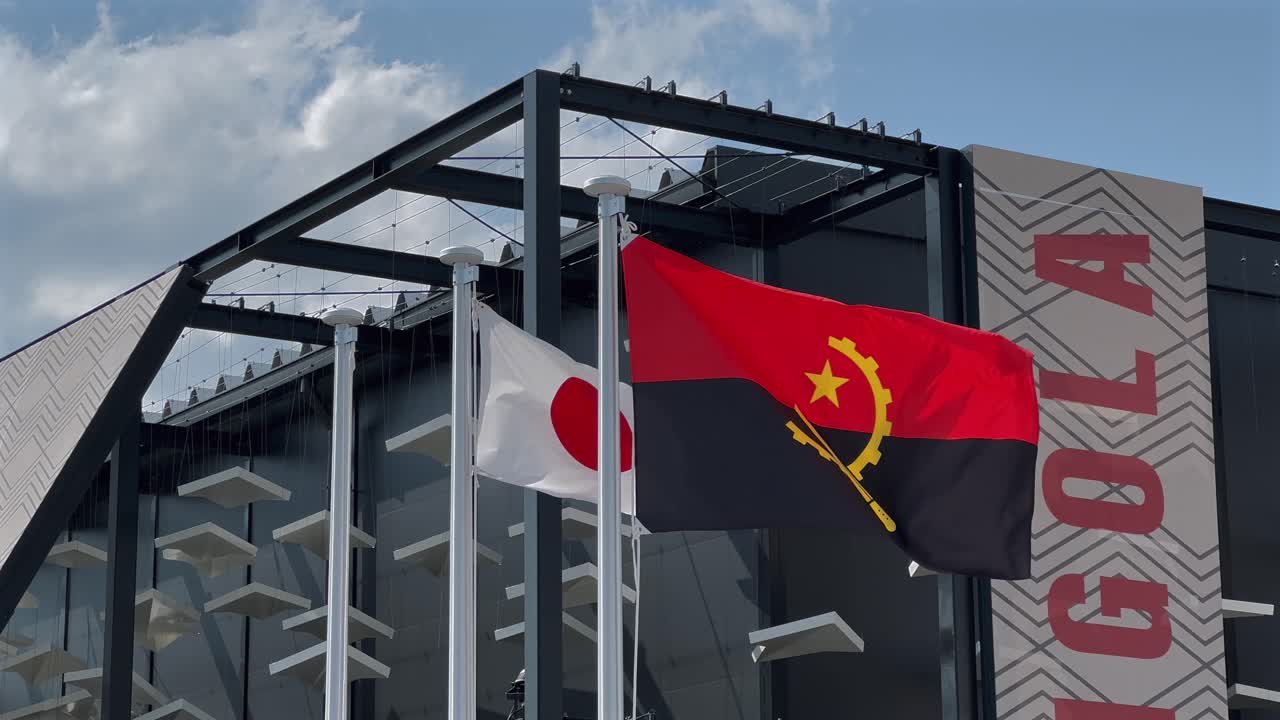 The Japanese and Angolan flags flutter in the spring breeze outside the Angola Pavilion at Expo 2025 Osaka, Japan. A vivid display of diplomacy, culture and global unity