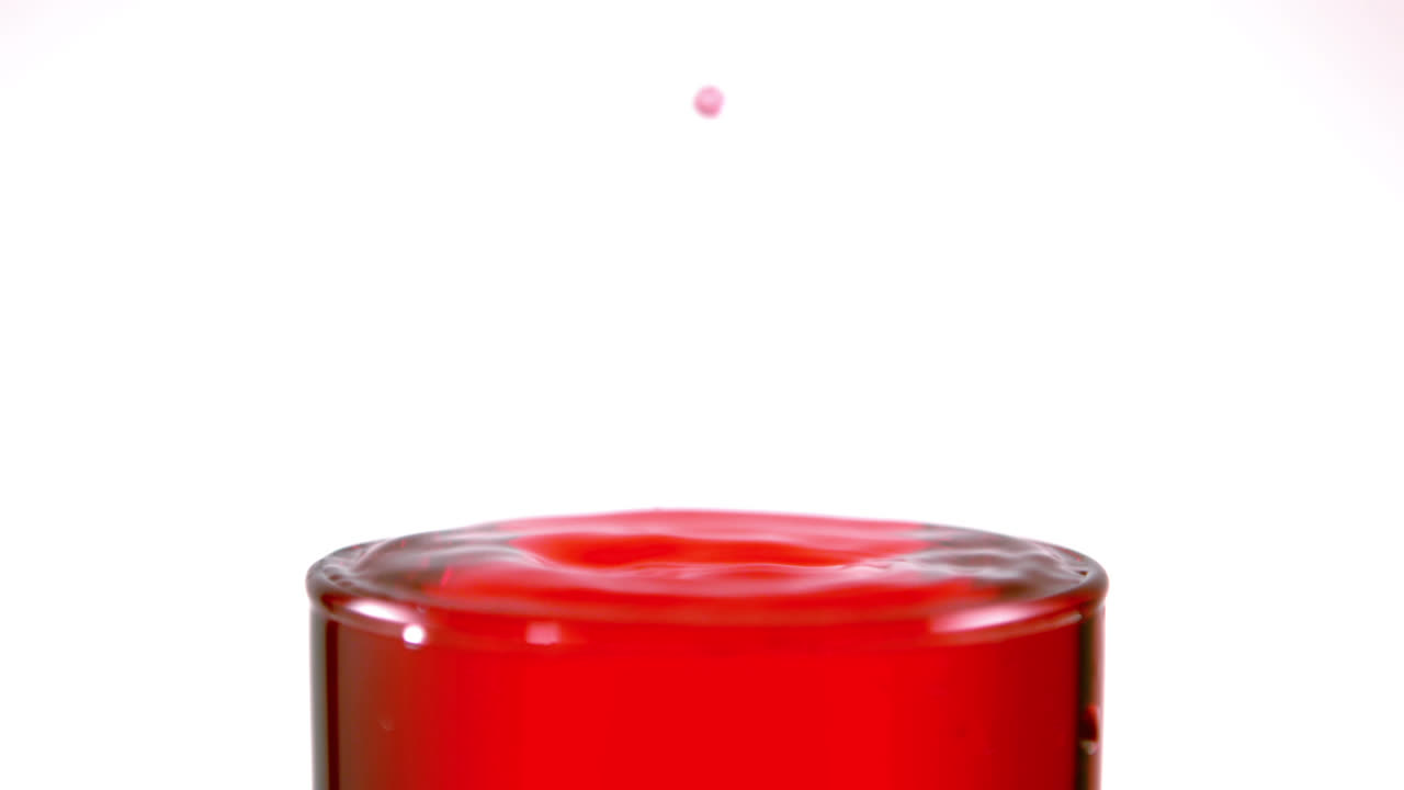 유리잔 속에 느린 움직임으로 떨어지는 방울
