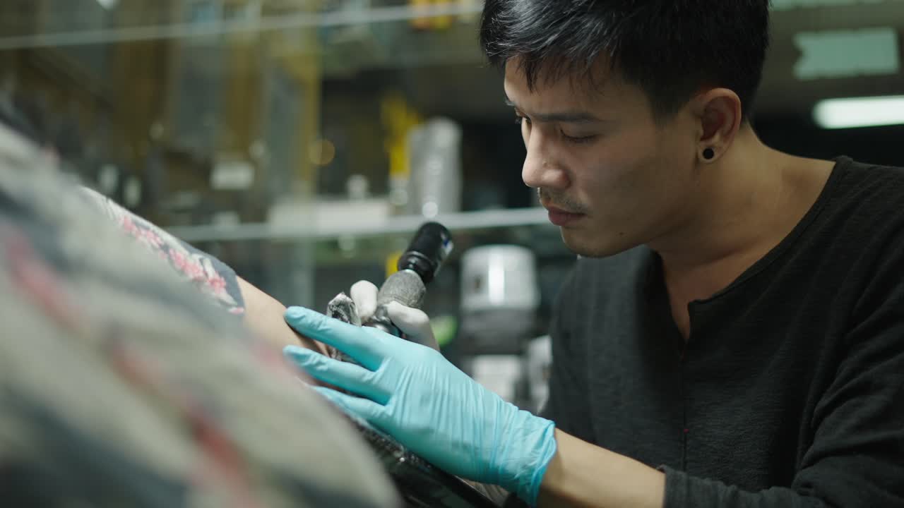 Tattoo Artist Working on a Client's Arm