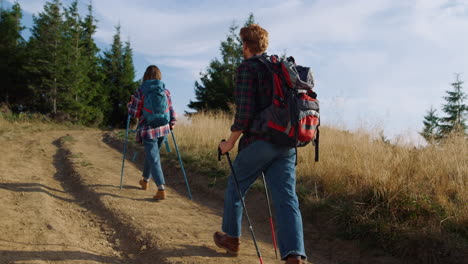 Hombre-Y-Mujer-Caminando-Por-La-Carretera-En-Las-Montañas.