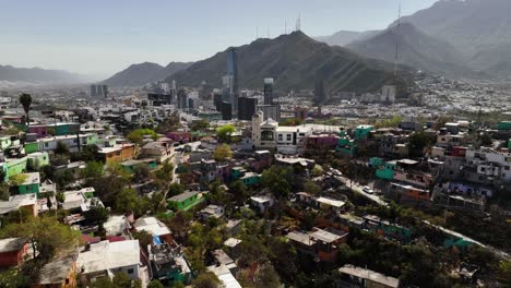 vista aérea lejos de las coloridas casas de pobreza con el horizonte de la ciudad en el fondo en el soleado monterrey, méxico