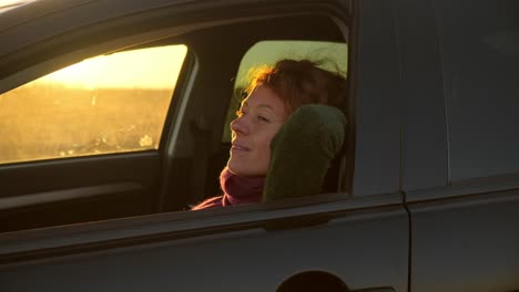 woman driving in a car at sunrise/sunset
