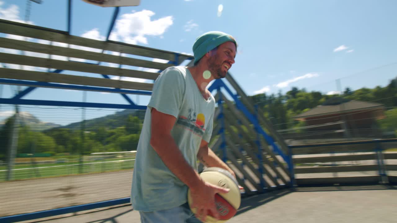 A man turns around then throws basketball into the ring on an outdoor court