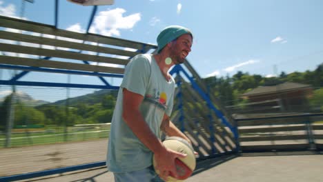 a man turns around then throws basketball into the ring on an outdoor court