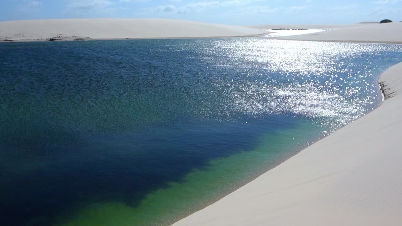 Tropical beach in Lencois Maranhenses, Brazil. Sandy beach with palms and blue transparent ocean. Aerial view