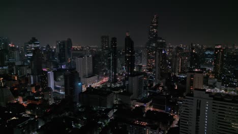 Rascacielos-Y-Edificios-En-Bangkok,-Tailandia-Durante-La-Noche---Disparo-Aéreo-De-Drones