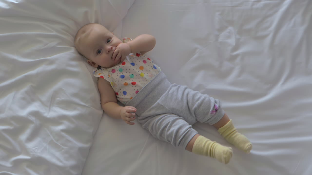 Neonata tranquilla sul letto a casa
