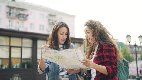 two women looking at a map in a city