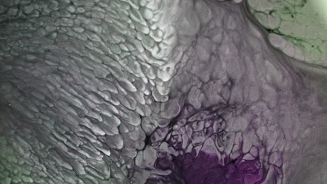 green and purple substances blend in an abstract pattern, close-up macro view