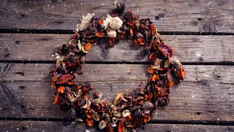 falling snow with christmas wreath on wood