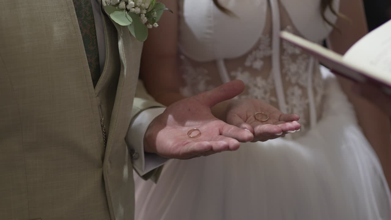 Sposi che tengono le fedi nuziali nelle loro mani durante la cerimonia, a simboleggiare amore e impegno