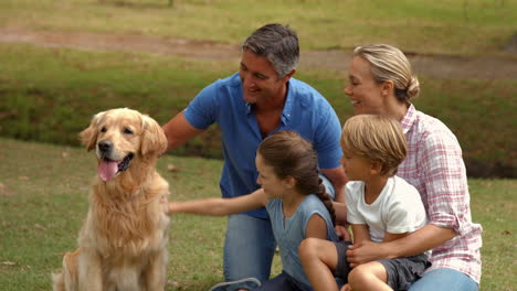familia feliz sonriendo a la cámara con su perro