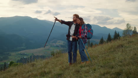 two tourists talk outdoors on mountains hike. travelers couple trekking nature.