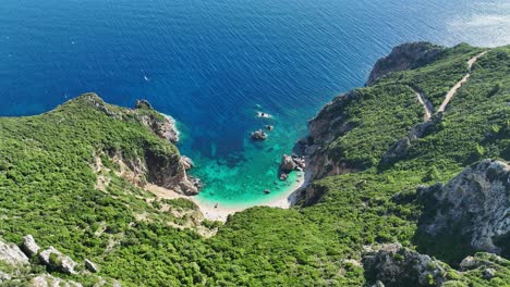 Giali-beach-in-corfu,-greece-with-turquoise-waters-and-rugged-cliffs,-aerial-view