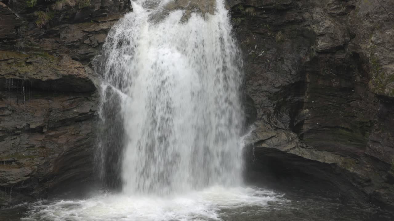 Sakte vippende opptak som viser vannet som fosser gjennom Falls of Falloch
