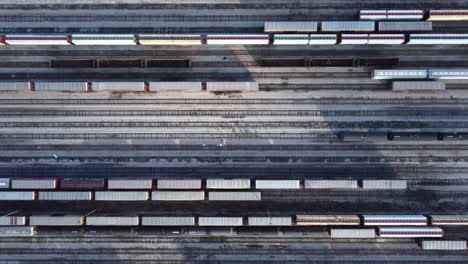 drone shot of railways, flying above industrial railroad station with cargo trains and freight containers