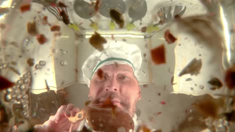 el chef prepara caldo de verduras, el chef añade especias a la sopa, la vista desde la sartén en cámara lenta.