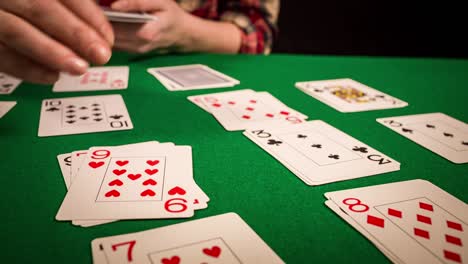 Close-up-of-female-hands-holding-cards-and-playing-solitaire