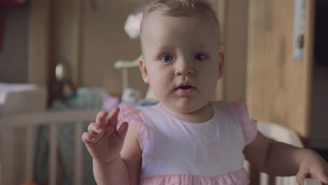 niña de pie y bailando en la cuna