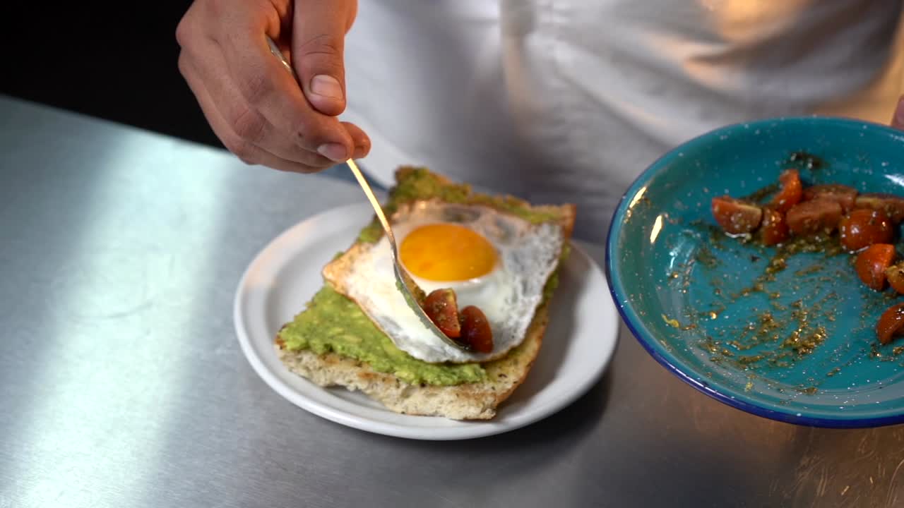 최고 슬로우 모션에 체리 토마토를 곁들인 아보카도 두꺼비 드레싱을 준비하는 요리사