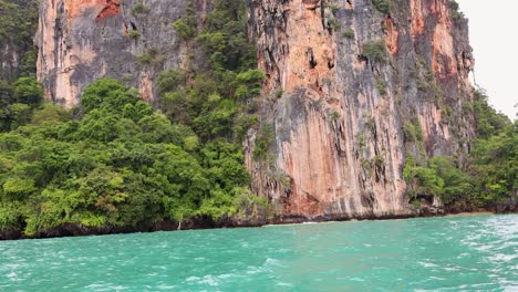 long-tail boat journey past lush cliffs