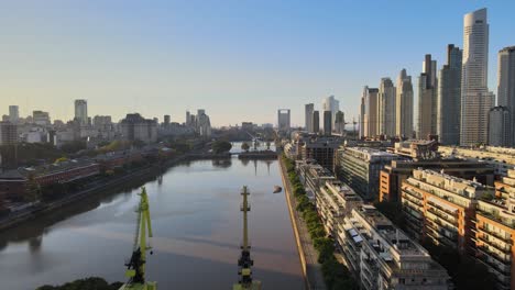 Luftaufnahme,-Die-über-Kranen-In-Puerto-Madero-Am-Wasser-Bei-Sonnenuntergang-In-Der-Stadt-Buenos-Aires-Fliegt