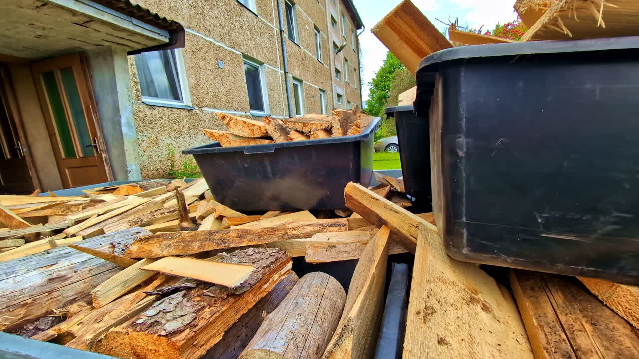 Plastic Bins With Chopped Firewood On Pile Of Logs Outside For Drying. closeup shot