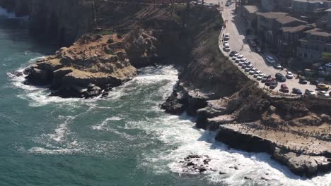 la jolla cove and beach surrounded by cliffs in san diego, california - aerial reveal