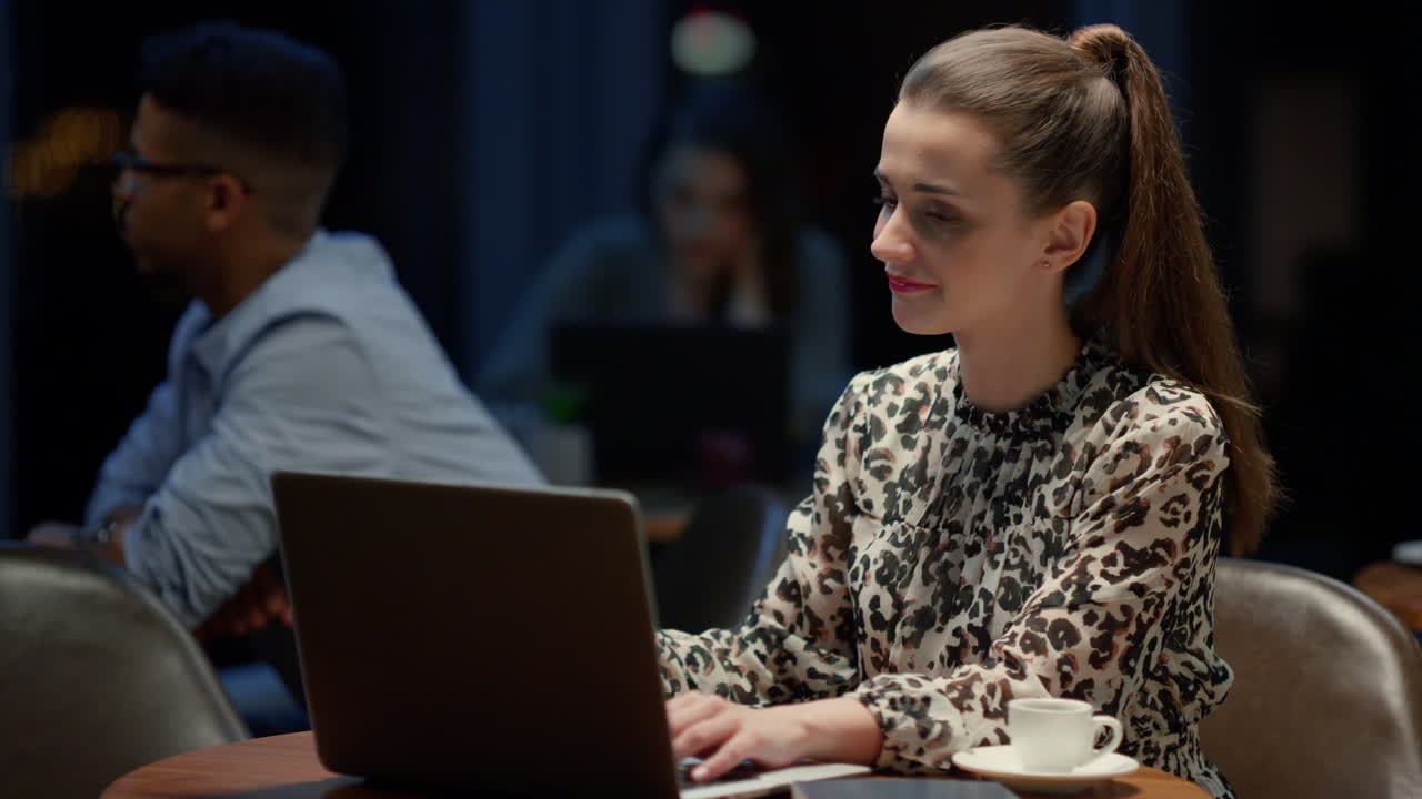 Cheerful businesswoman using laptop in cafe