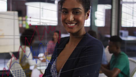 animación de un gráfico financiero sobre una mujer de negocios biracial sonriente en la oficina
