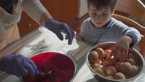 footage of family painting easter eggs in a greek village indoors