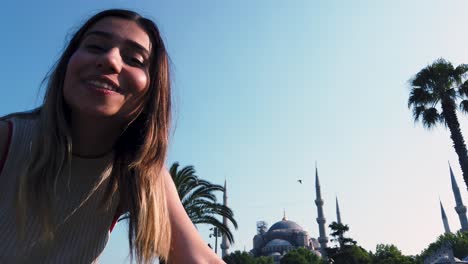 beautiful young girls waves turkish flag with view of sultan ahmed or blue mosque in i̇stanbul,turkey,travel concept