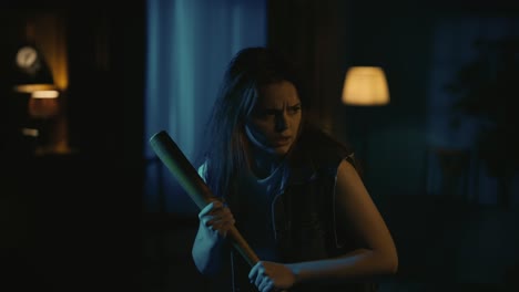 young woman holding baseball bat in a dark room