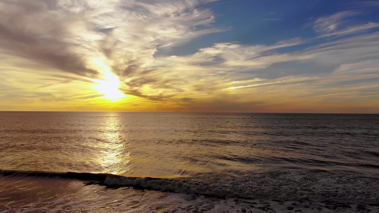 pintoresca vista mágica de la puesta de sol con agua de mar que fluye en primer plano, durante la hora dorada