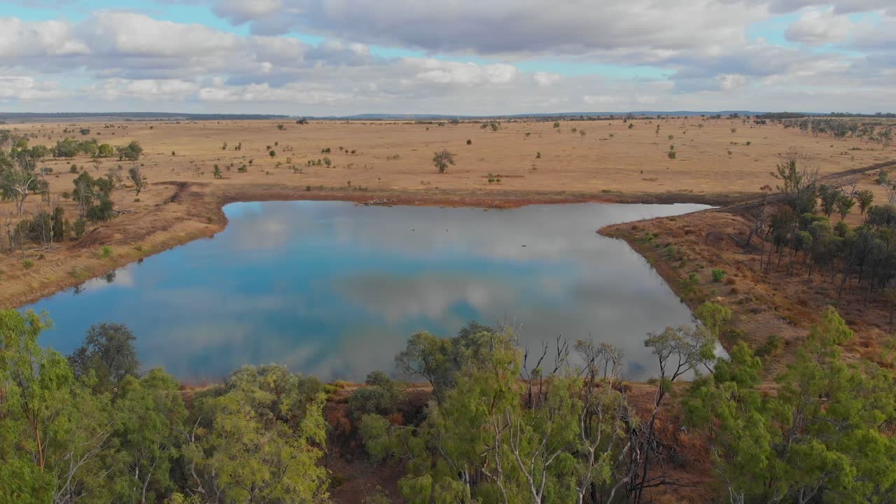 Lagoa isolada no outback com árvores esparsas em Emerald, Queensland, Austrália