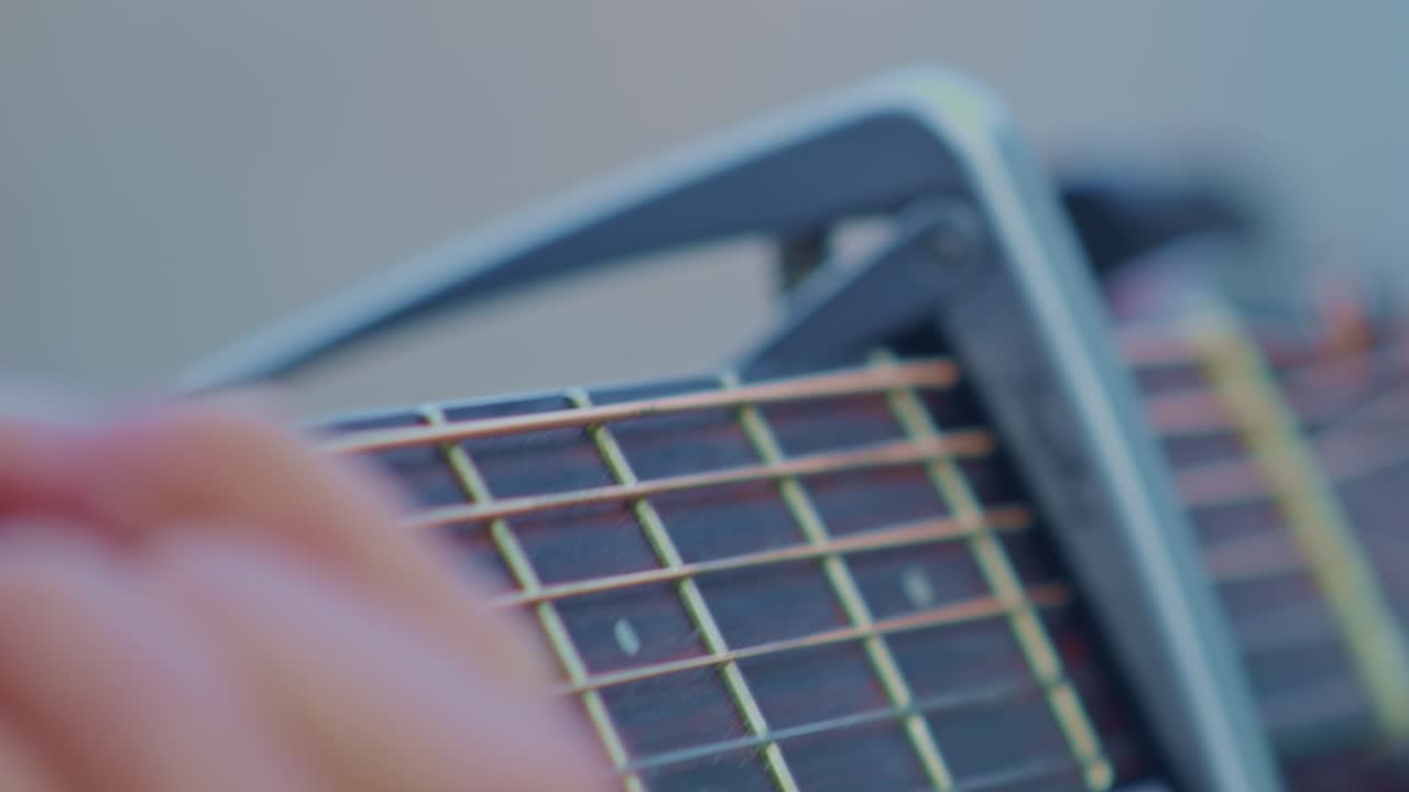 Guitarist plays guitar, super ultra closeup view of hand wrist, fingers, frets and strings