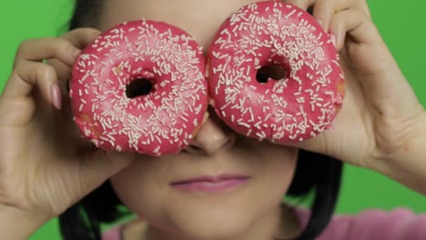 Happy-beautiful-young-girl-posing-and-having-fun-with-donuts.-Chroma-key