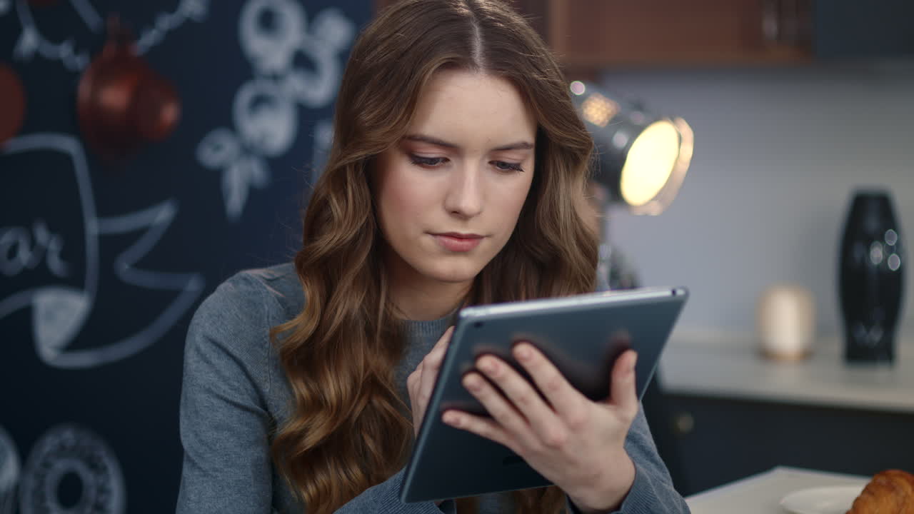 Focused business woman searching information on tablet computer at home office.