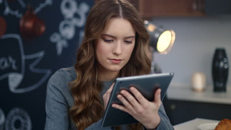 focused business woman searching information on tablet computer at home office.