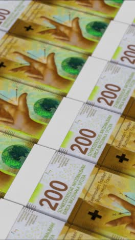 vertical video of 200 swiss franc banknotes printing by a money press