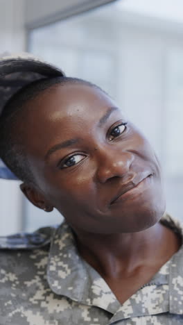 vertical video portrait of smiling african american female soldier in hospital, slow motion