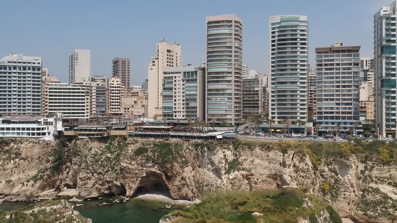 disparo de grúa que se levanta revelando el hermoso paisaje urbano de beirut en el fondo de rocas de palomas, líbano