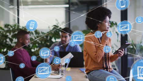 animation of media icons over diverse business people using tablet and thinking