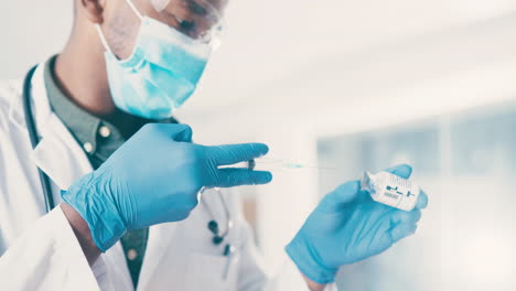 un joven médico preparando inyectables