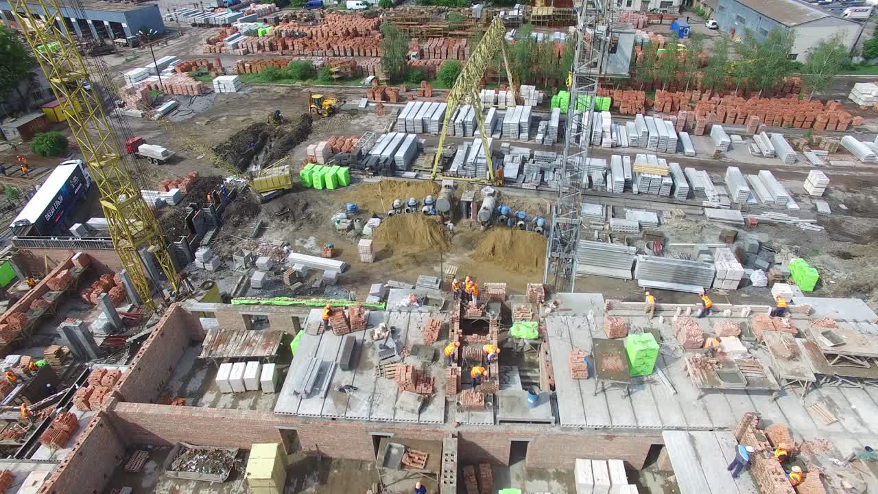 VINNITSA, UKRAINE - JUNE 2016: Aerial shot of the professional construction worker laying bricks in industrial site